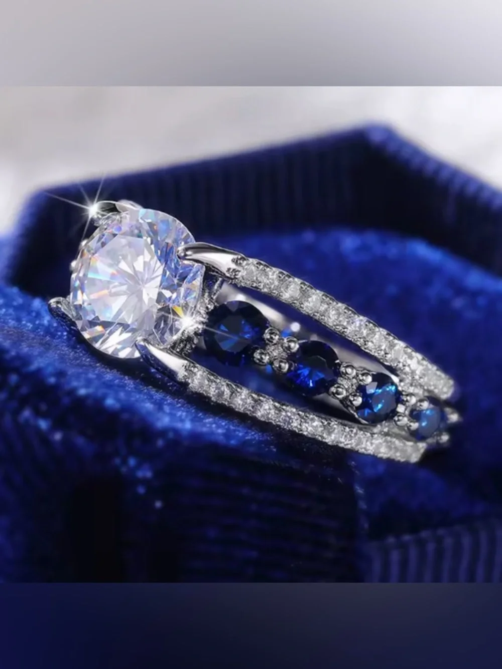 Silver Ring with Deep Blue Stones and Clear Center Gem.